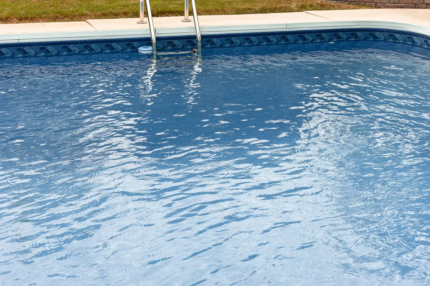 Residential in-ground swimming pool with a molded curved shell