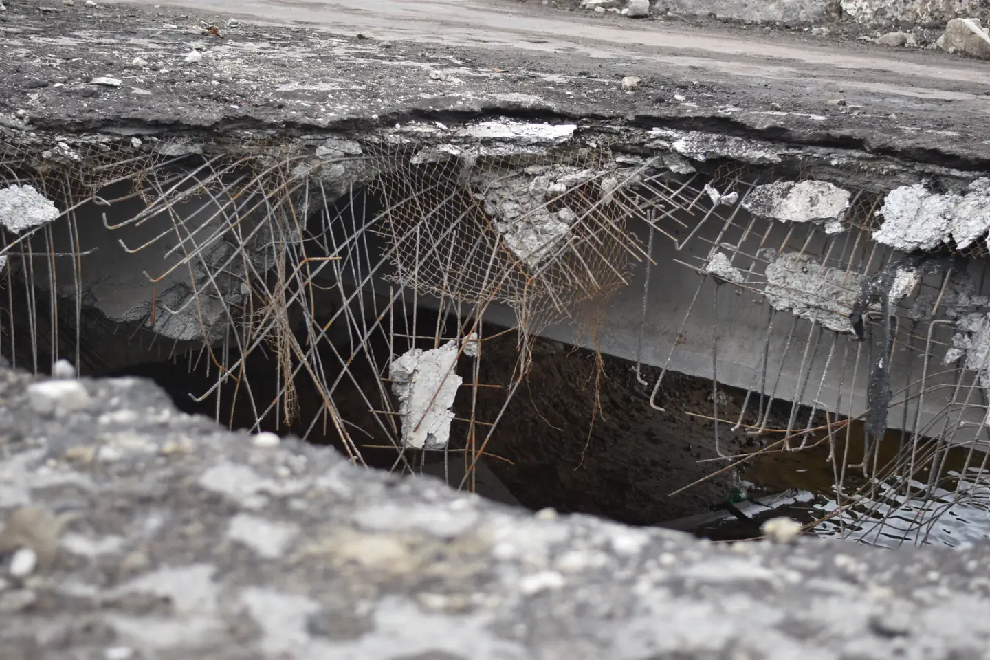 Broken concrete slab with exposed rebar reinforcement