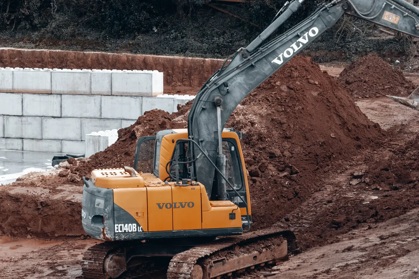 Excavator moving earth at a demolition and backfill site